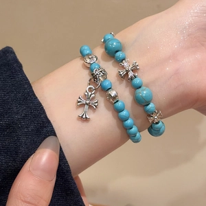 Gros plan détaillé d'un bracelet en perles de turquoise avec pendentif croix en argent