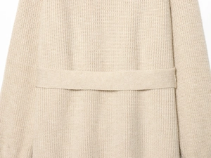 Détail de la maille côtelée beige et de la ceinture assortie sur le gilet en tricot