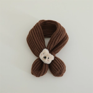 Detail of dark brown knitted kids scarf with a cute plush bear head on the cross strap