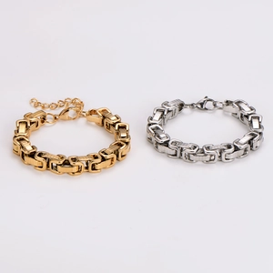 Close-up of industrial square link chain bracelets in polished gold and silver steel
