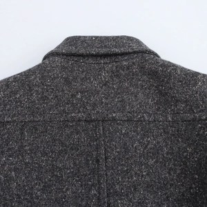 Detailed close-up of dark grey wool blend texture and back collar on a classic coat