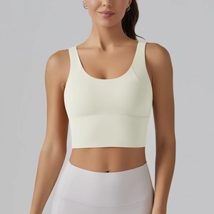 Close-up of light yellow U-neck sports bra with wide straps and purple leggings