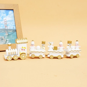 Side view of white and gold wooden Christmas train with snowman and bear figures