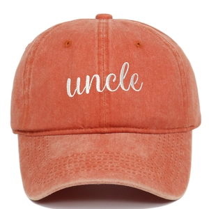 Detailaufnahme der weißen Uncle-Stickerei auf einer verwaschenen terracotta Baseballkappe