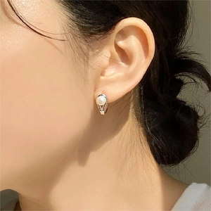 Minimalist 925 sterling silver pearl earrings worn by a model in soft natural light