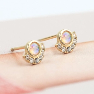 Elegant gold opal stud earrings with shimmering zircon halo on a soft gradient background