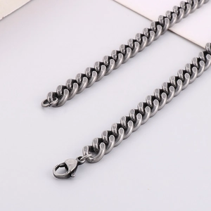Macro shot of vintage dark silver stainless steel Cuban chain necklace with lobster clasp