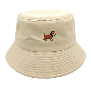 Detailed embroidery of a cartoon puppy on a beige cotton bucket hat with parallel stitching