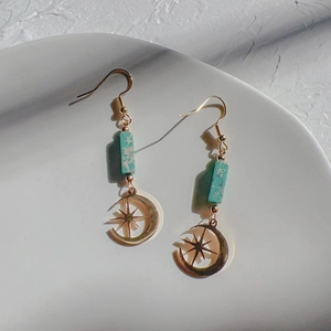 Detail of 18K gold moon and star hook earrings with green turquoise rectangular stone
