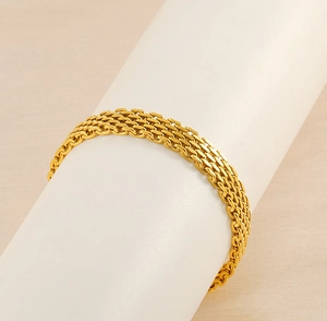 Macro shot of gold woven mesh texture on vintage stainless steel braided bracelet
