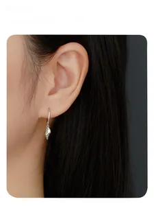 Detailed view of S925 silver hoop earrings with seashell pendants worn by a female model