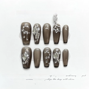 Detailed view of handmade Christmas press-on nails with silver rhinestones and star pendant