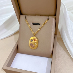 Detail of gold titanium steel necklace with colorful gems in a jewelry box