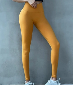Detailansicht der senfgelben Yoga-Hose mit hoher Taille und elastischer Stoffstruktur