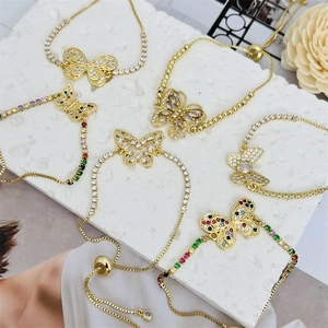 Detailed view of 18k gold plated butterfly bracelets with colorful zircon stones on marble