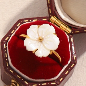 Macro shot of 18K gold plated flower ring with white shell petals in a velvet gift box