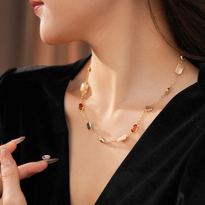 Gros plan d'un collier vintage doré avec coquillage et pierres colorées