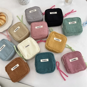 Flat lay of colorful corduroy mini cosmetic bags showing various color options and texture