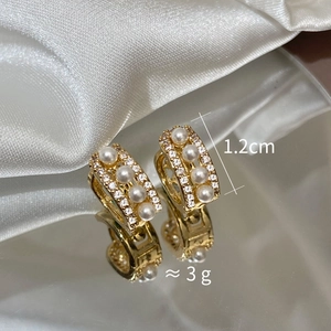 Detailed view of 1.2cm gold earrings featuring four white pearls and micro-pave crystals