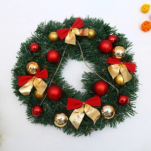 Couronne de Noël verte avec boules et nœuds rouges et dorés sur fond blanc