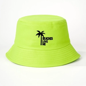 Close-up of neon green bucket hat featuring black palm tree and BEACHES LOVE ME text