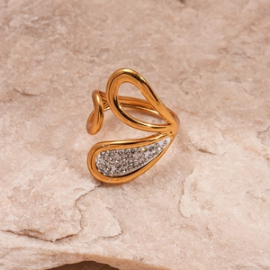 Detailed macro view of gold-plated wavy leaf ring with diamond accents on rock