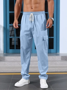 Close-up of light blue cargo pants with side flap pockets and white drawstring waist
