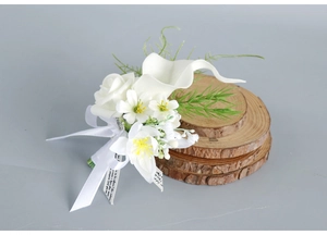 Detailed close-up of white calla lily and rose boutonniere with elegant ribbon detail