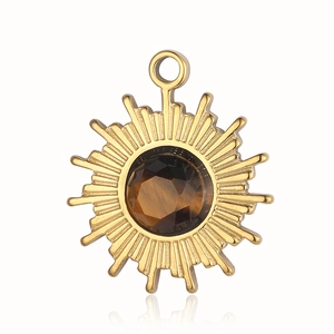 Detail of a golden sun pendant with a brown faceted tiger eye stone on white background