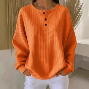 Fashionable orange waffle knit long sleeve henley shirt with a relaxed fit for men