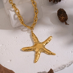 Macro shot of gold hammered starfish pendant on a heavy stainless steel chunky chain