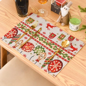 Christmas knitted placemat with red reindeer and green holly patterns on a wooden table