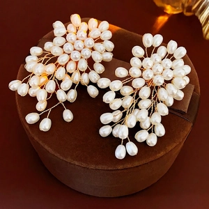 Boucles d'oreilles fleurs en perles faites main avec fil doré sur boîte à bijoux