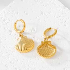 Macro shot of gold stainless steel shell earrings with embossed texture on stone base