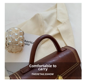 Close-up of comfortable leather handle and gold rivet details on vintage crossbody bag