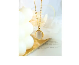 Detailed close-up of a gold oval cat-eye stone pendant on a vintage titanium chain