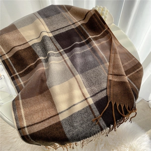 Close-up of thick plaid winter scarf with fringe details in coffee and beige colors