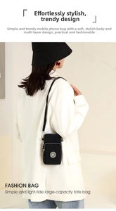 Rear view of a black nylon crossbody phone bag with double zippers and star emblem