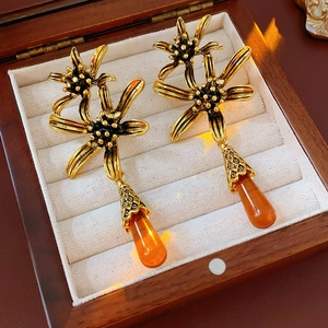 Detailed close-up of vintage flower earrings with amber water drop pendants on a jewelry box