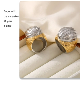 Close-up of vintage wide hammer-textured gold rings with silver shell-like tops