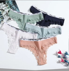 Détail de cinq strings en coton avec dentelle et texte Love You sur la ceinture