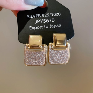 Detailed macro view of 18k gold plated square earrings with pink glitter inlay