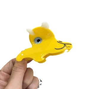 Cute yellow acetate monster hair claw clip with cream horns for creative hair styling