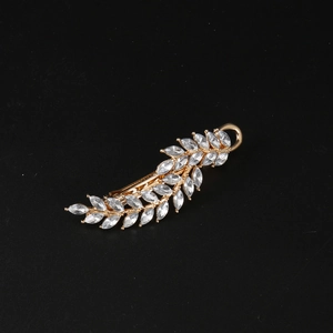 Detailed view of leaf-shaped gold hair clip with sparkling marquise-cut crystal rhinestones