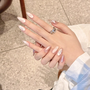 Long almond press-on nails in pearlescent pink with 3D butterfly and pearl accents