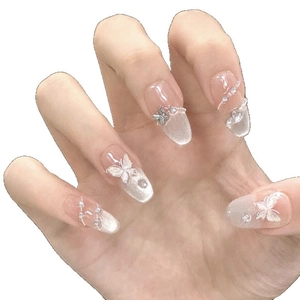 Cat eye press-on nails with silver butterflies, pearls, and crystals on oval shape