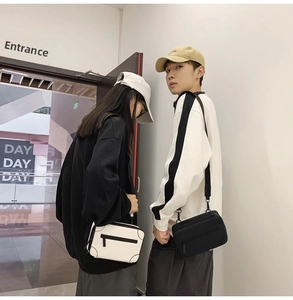 Detail of couple wearing black and white tactical nylon crossbody bags with wide straps