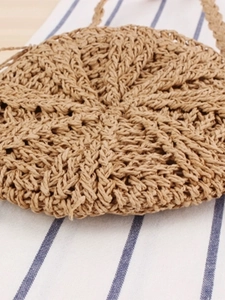Handcrafted circular straw woven bag with fringe detailing for casual summer beach vacations