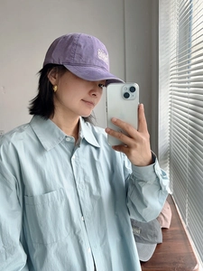 Detalle de gorra de béisbol de algodón violeta lavado con bordado en blanco