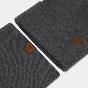 Detailed knit texture of dark grey winter hat and scarf with snowflake leather label